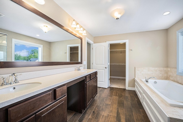 2380 Avalon Woods Dr, Portage, MI 49024 - full bath featuring wood finished floors, a bath, a walk in closet, double vanity, and baseboards