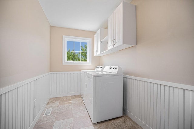 2380 Avalon Woods Dr, Portage, MI 49024 - laundry area with separate washer and dryer, cabinet space, a wainscoted wall, and light stone finish flooring
