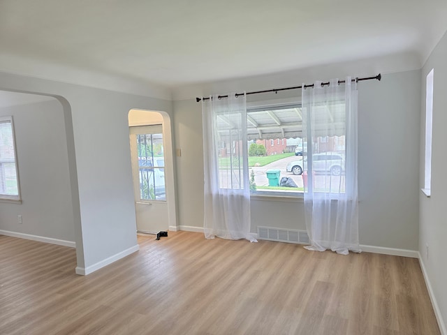 15360 Collinson Ave, Eastpointe, MI 48021 - spare room featuring arched walkways, light wood-style flooring, and baseboards