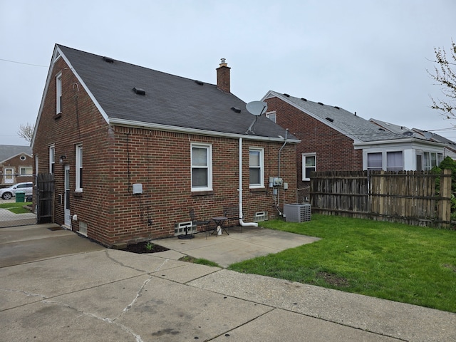 15360 Collinson Ave, Eastpointe, MI 48021 - rear view of house with brick siding, a chimney, central AC unit, roof with shingles, and a patio area