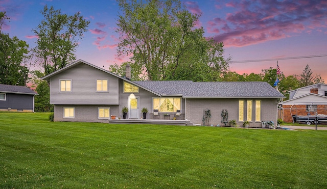 3488 Hilton Estates Dr, Brighton, MI 48114 - view of front of home featuring a chimney, a front lawn, brick siding, and a deck