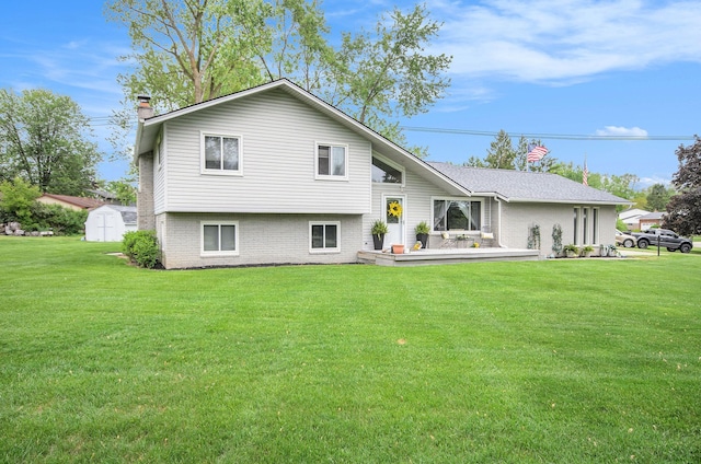 3488 Hilton Estates Dr, Brighton, MI 48114 - rear view of house featuring a chimney, a lawn, a deck, and brick siding
