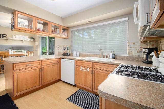 3488 Hilton Estates Dr, Brighton, MI 48114 - kitchen with a sink, white appliances, a peninsula, light wood-type flooring, and glass insert cabinets