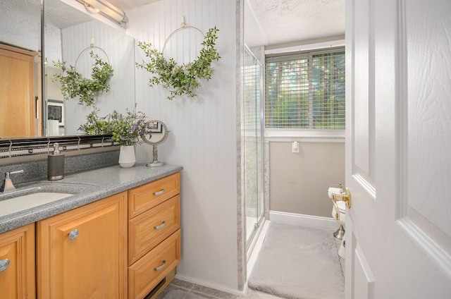 3488 Hilton Estates Dr, Brighton, MI 48114 - full bathroom featuring a stall shower, vanity, a textured ceiling, and baseboards