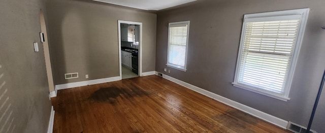 spare room with dark wood-style flooring and baseboards