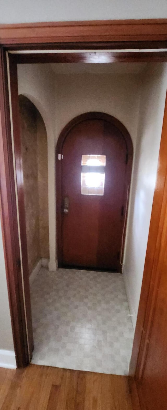 hall featuring arched walkways and light flooring