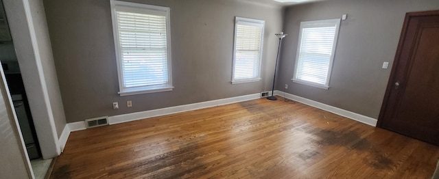 spare room with wood finished floors and baseboards