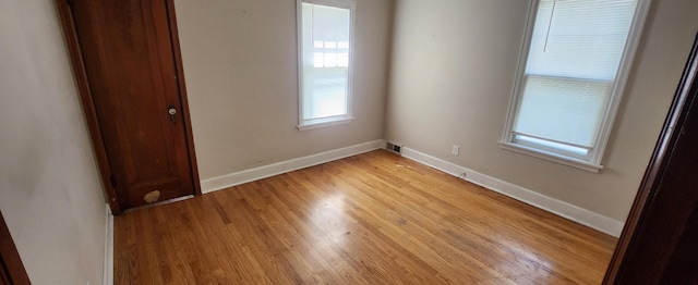 empty room featuring light wood-type flooring and baseboards