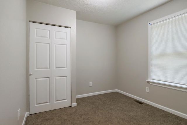 202 Haltiner St, River Rouge, MI 48218 - unfurnished bedroom with carpet flooring, a closet, baseboards, and a textured ceiling