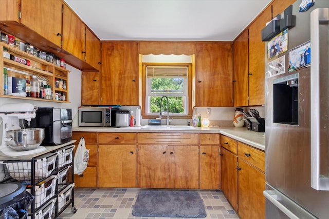 716 Allen St, Caro, MI 48723 - kitchen with a sink, stainless steel appliances, light countertops, and brown cabinetry