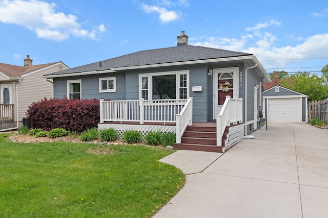 view of front facade with an outdoor structure, a detached garage, a front lawn, concrete driveway, and a chimney