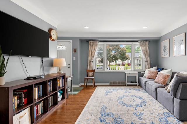 living area with healthy amount of natural light, wood finished floors, recessed lighting, and baseboards