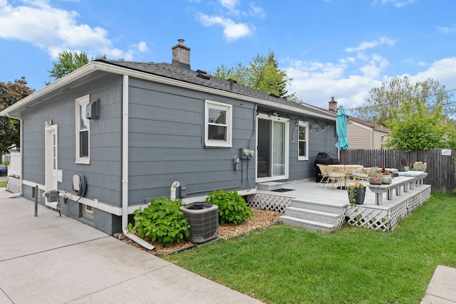 rear view of property featuring a chimney, a wooden deck, and cooling unit
