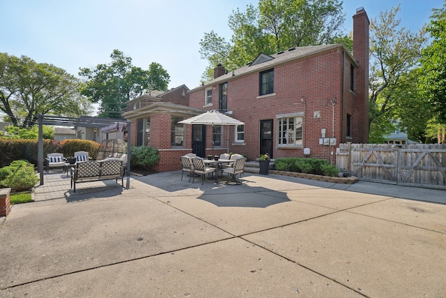 441 Roland Rd, Grosse Pointe Farms, MI 48236 - back of house featuring a chimney, brick siding, a patio area, and fence