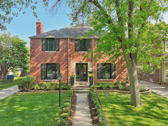 441 Roland Rd, Grosse Pointe Farms, MI 48236 - view of front of home with brick siding, a chimney, and a front yard