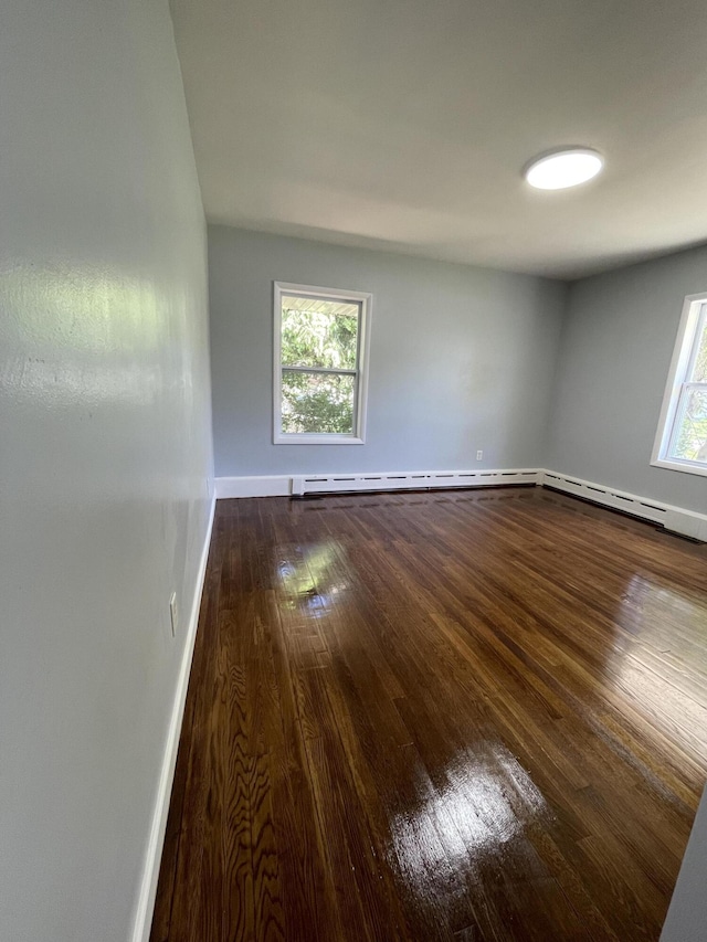 1648 Columbus Ave, Benton Harbor, MI 49022 - spare room featuring dark wood-style flooring, baseboards, and a baseboard radiator