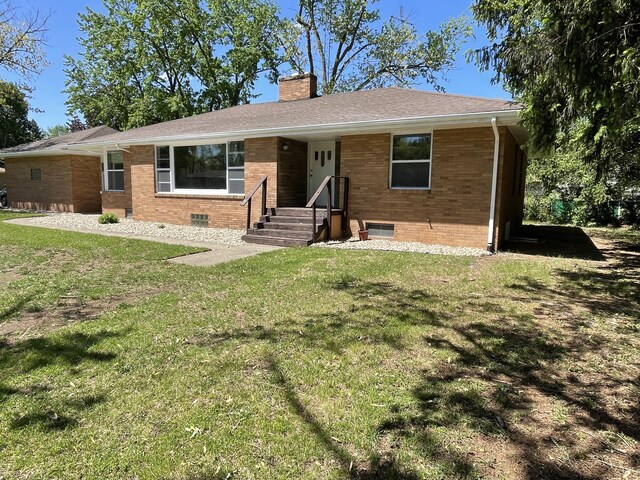 1648 Columbus Ave, Benton Harbor, MI 49022 - ranch-style home with a chimney, brick siding, and a front lawn