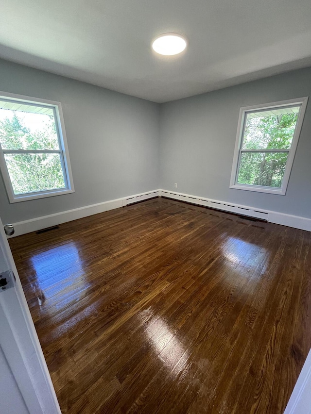 1648 Columbus Ave, Benton Harbor, MI 49022 - spare room with dark wood finished floors, a baseboard heating unit, and baseboards