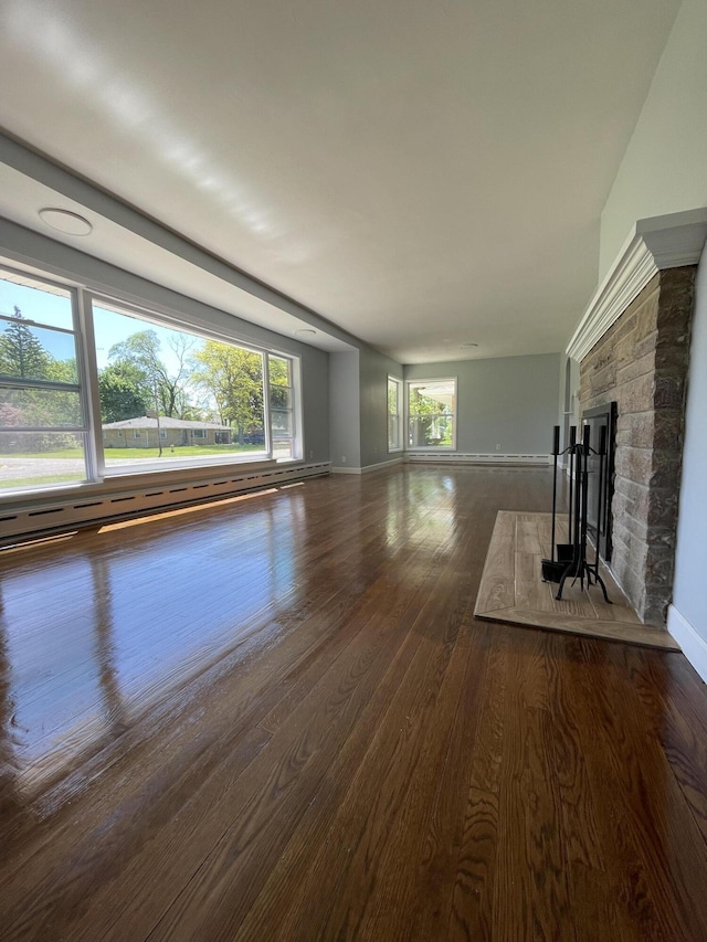 1648 Columbus Ave, Benton Harbor, MI 49022 - unfurnished living room with dark wood-style floors, baseboards, baseboard heating, and a stone fireplace