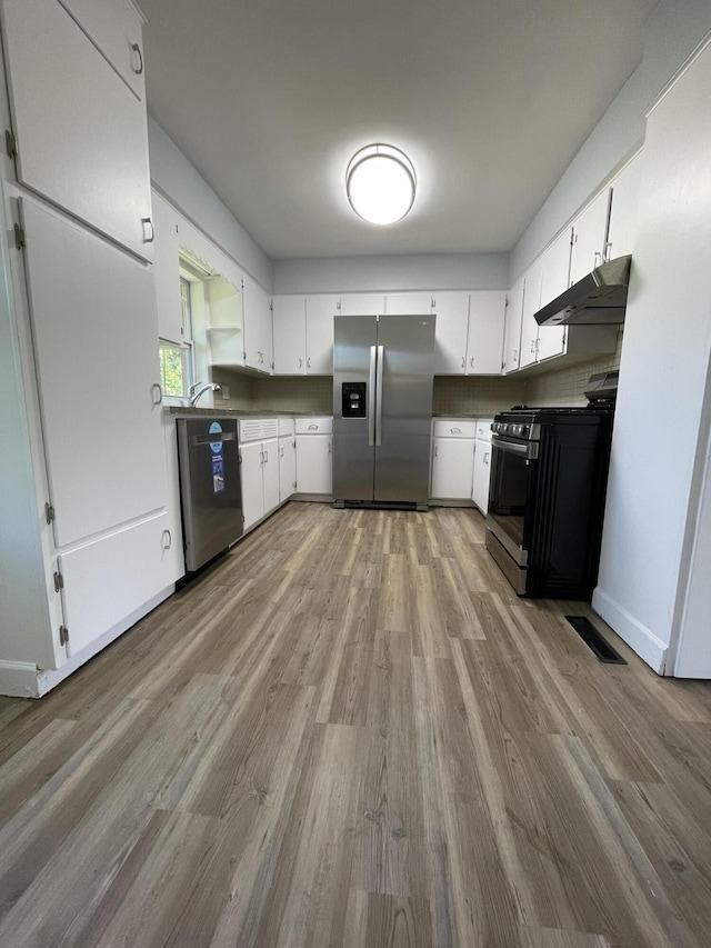 1648 Columbus Ave, Benton Harbor, MI 49022 - kitchen featuring stainless steel appliances, under cabinet range hood, wood finished floors, and white cabinetry