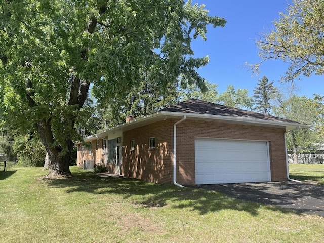 1648 Columbus Ave, Benton Harbor, MI 49022 - view of side of home with brick siding, a lawn, a garage, and driveway
