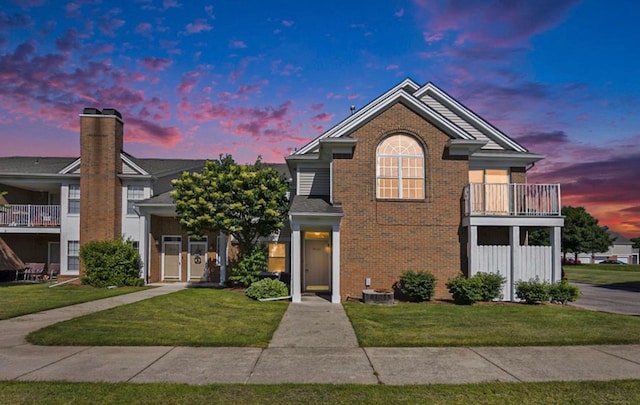 46265 Cavalier Dr, Macomb, MI 48044 - traditional home with brick siding, a lawn, cooling unit, and a balcony