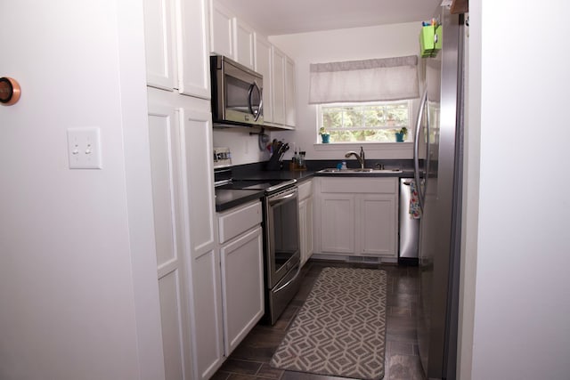 46265 Cavalier Dr, Macomb, MI 48044 - kitchen featuring appliances with stainless steel finishes, dark countertops, white cabinetry, and a sink