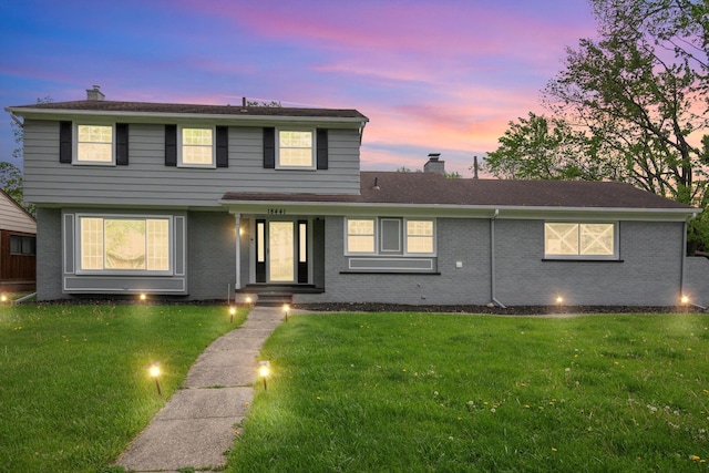 18441 Roseland Blvd, Lathrup Village, MI 48076 - view of front of house with a chimney, a yard, and brick siding
