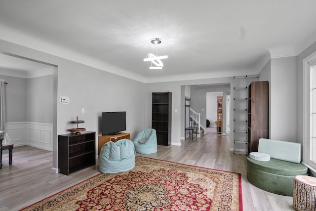 18441 Roseland Blvd, Lathrup Village, MI 48076 - living area featuring wood finished floors, a chandelier, stairs, and a wainscoted wall