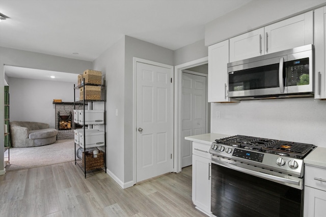 18441 Roseland Blvd, Lathrup Village, MI 48076 - kitchen featuring appliances with stainless steel finishes, light wood-style flooring, white cabinetry, and light countertops