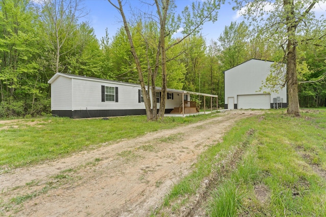 16747 Williamsville St, Vandalia, MI 49095 - view of front of home with a garage, dirt driveway, an outbuilding, and a front yard
