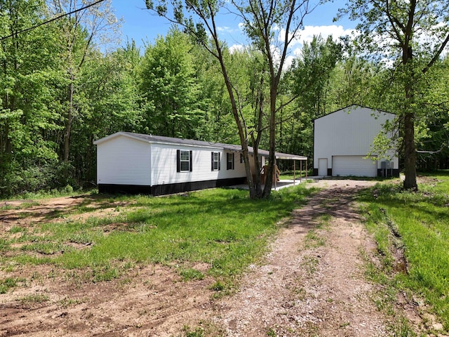 16747 Williamsville St, Vandalia, MI 49095 - view of front facade with an outdoor structure, a garage, and dirt driveway