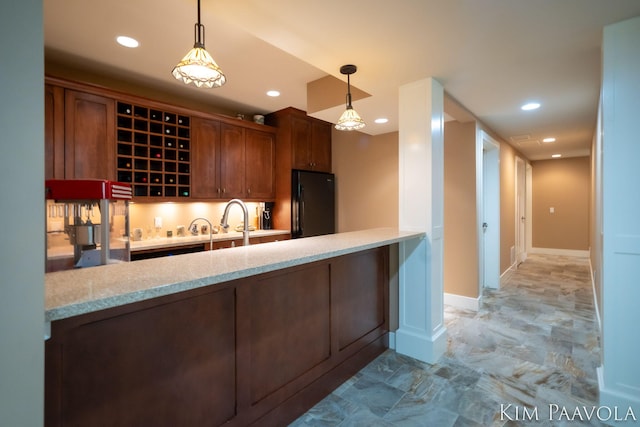 3099 Pickford Dr SE, Ada, MI 49301 - kitchen with freestanding refrigerator, a peninsula, recessed lighting, hanging light fixtures, and light stone counters