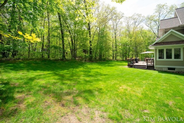 3099 Pickford Dr SE, Ada, MI 49301 - view of green lawn featuring a deck