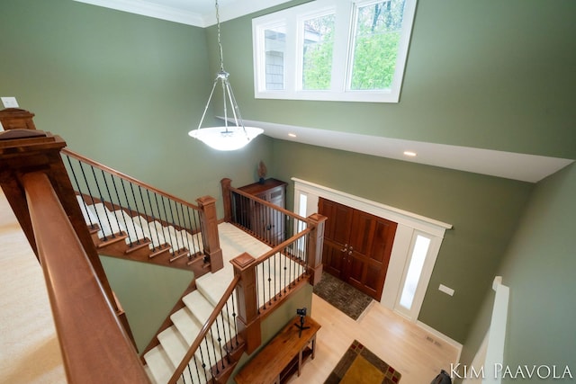 3099 Pickford Dr SE, Ada, MI 49301 - entryway featuring light wood finished floors, a high ceiling, ornamental molding, and recessed lighting