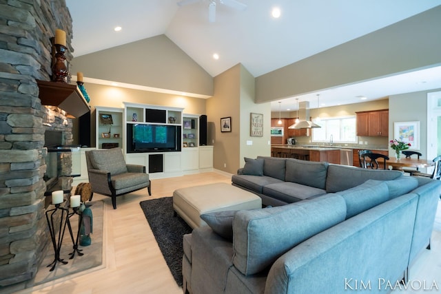 3099 Pickford Dr SE, Ada, MI 49301 - living room featuring high vaulted ceiling, light wood-style flooring, recessed lighting, and a stone fireplace