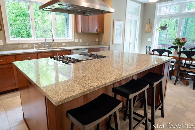 3099 Pickford Dr SE, Ada, MI 49301 - kitchen with wall chimney exhaust hood, a sink, brown cabinetry, and a kitchen island