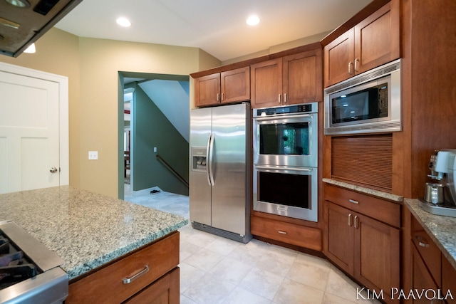 3099 Pickford Dr SE, Ada, MI 49301 - kitchen with stainless steel appliances, brown cabinets, light stone counters, and recessed lighting