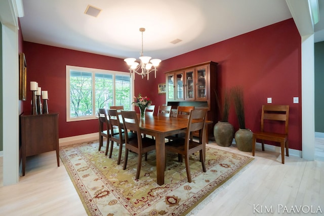 3099 Pickford Dr SE, Ada, MI 49301 - dining space with a chandelier, light wood-type flooring, and baseboards