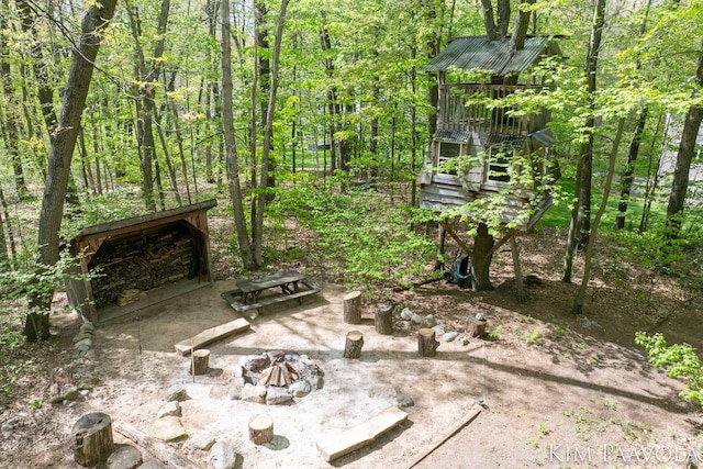 3099 Pickford Dr SE, Ada, MI 49301 - view of patio featuring an outdoor fire pit and a view of trees