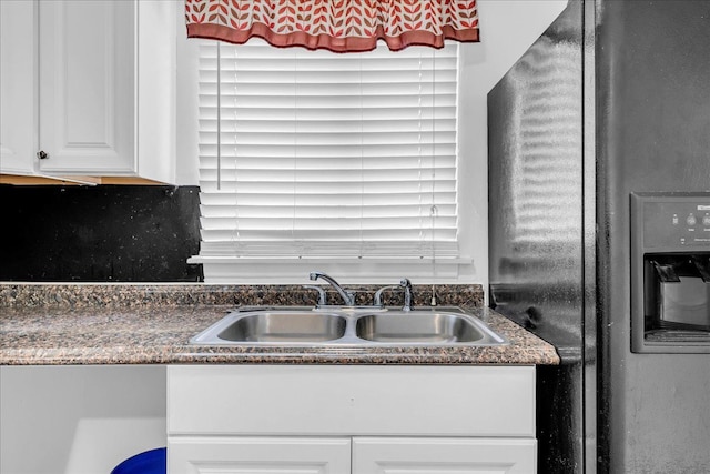 228 Hughes Ave, Pontiac, MI 48341 - kitchen featuring black fridge, a sink, white cabinetry, and dark stone countertops