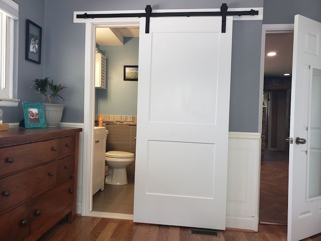 15701 Middlebelt Rd, Romulus, MI 48174 - bathroom featuring wainscoting, toilet, wood finished floors, and vanity