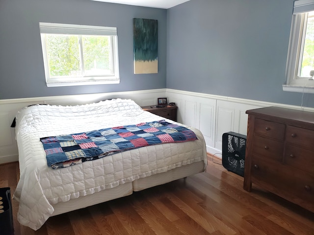 15701 Middlebelt Rd, Romulus, MI 48174 - bedroom with wood finished floors, a wainscoted wall, and a decorative wall
