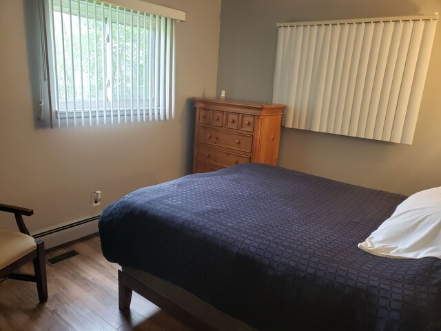 15701 Middlebelt Rd, Romulus, MI 48174 - bedroom with a baseboard radiator and wood finished floors
