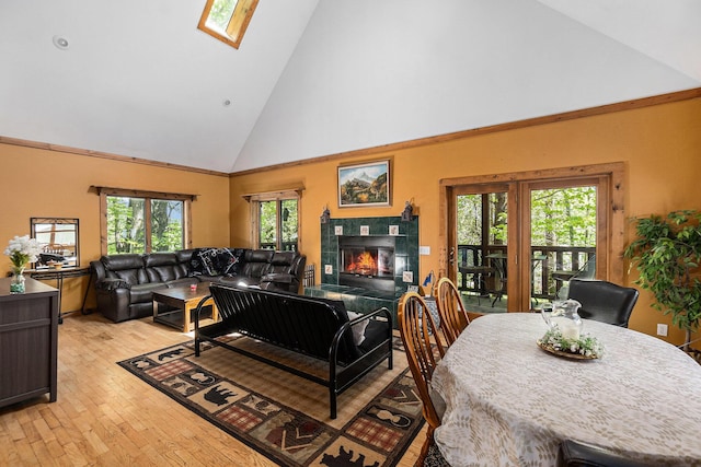 18862 Oxbow Dr, Barryton, MI 49305 - living room featuring high vaulted ceiling, a skylight, light wood-style floors, and a tiled fireplace