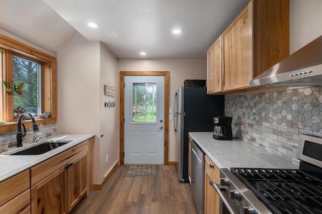 18862 Oxbow Dr, Barryton, MI 49305 - kitchen with appliances with stainless steel finishes, wall chimney range hood, a sink, dark wood-style flooring, and tasteful backsplash