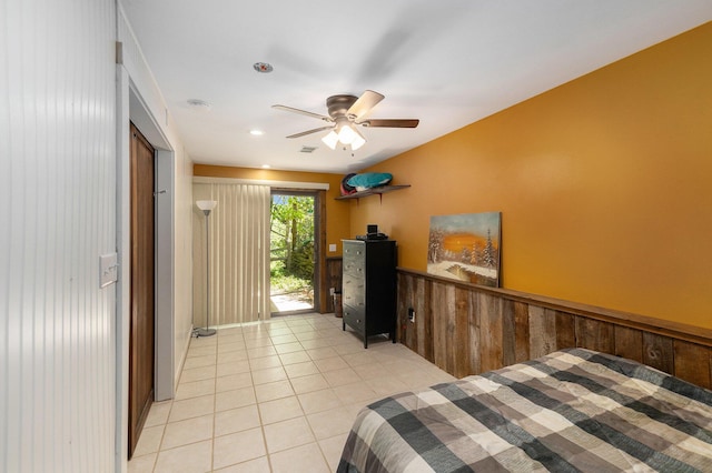 18862 Oxbow Dr, Barryton, MI 49305 - bedroom with light tile patterned flooring, a ceiling fan, wainscoting, and wooden walls