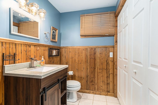 18862 Oxbow Dr, Barryton, MI 49305 - bathroom with wainscoting, toilet, tile patterned flooring, vanity, and wood walls