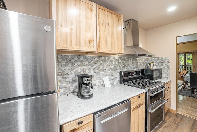 18862 Oxbow Dr, Barryton, MI 49305 - kitchen featuring appliances with stainless steel finishes, light brown cabinetry, wall chimney exhaust hood, dark wood-style floors, and tasteful backsplash