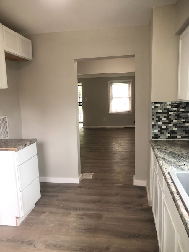 2422 Missouri Ave, Flint, MI 48506 - kitchen featuring white cabinetry, baseboards, dark wood-type flooring, and backsplash